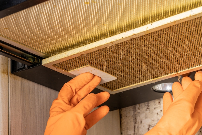cleaning and washing dirty cooker hood filter. fat and dust at filter. domestic kitchen.