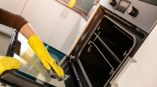 Someone cleaning an oven door