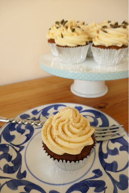 pumpkin cupcake with maple syrup buttercream on blue plate